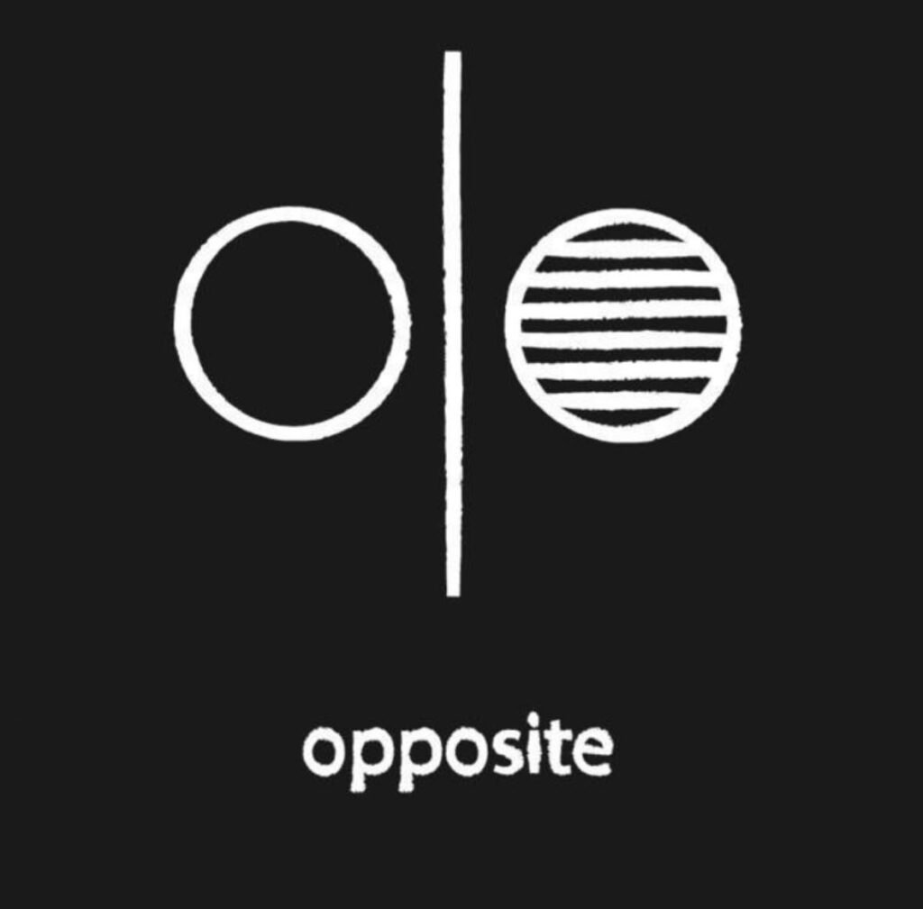 O símbolo dos dois círculos separados por uma linha vertical sintetiza essa travessia entre o antes — um território de contenção, silêncio e gestos íntimos — e o depois, onde a cor se expande, as camadas se intensificam e a afirmação ganha força.